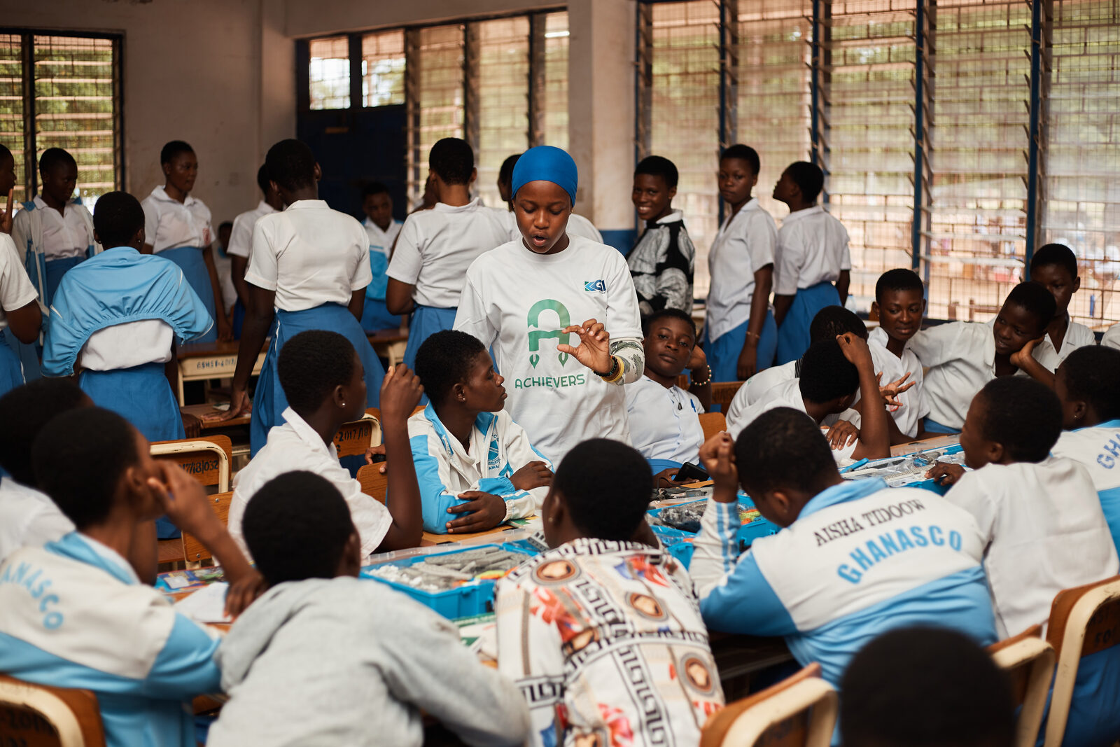 Achievers Ghana mentor teaching girls in a classroom session