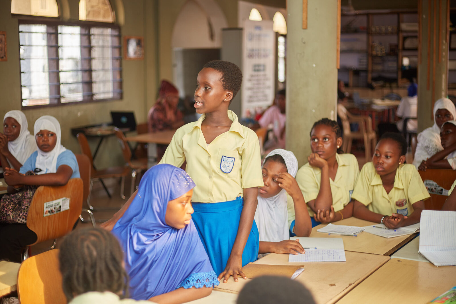 Achievers Ghana students standing together in front of a community building